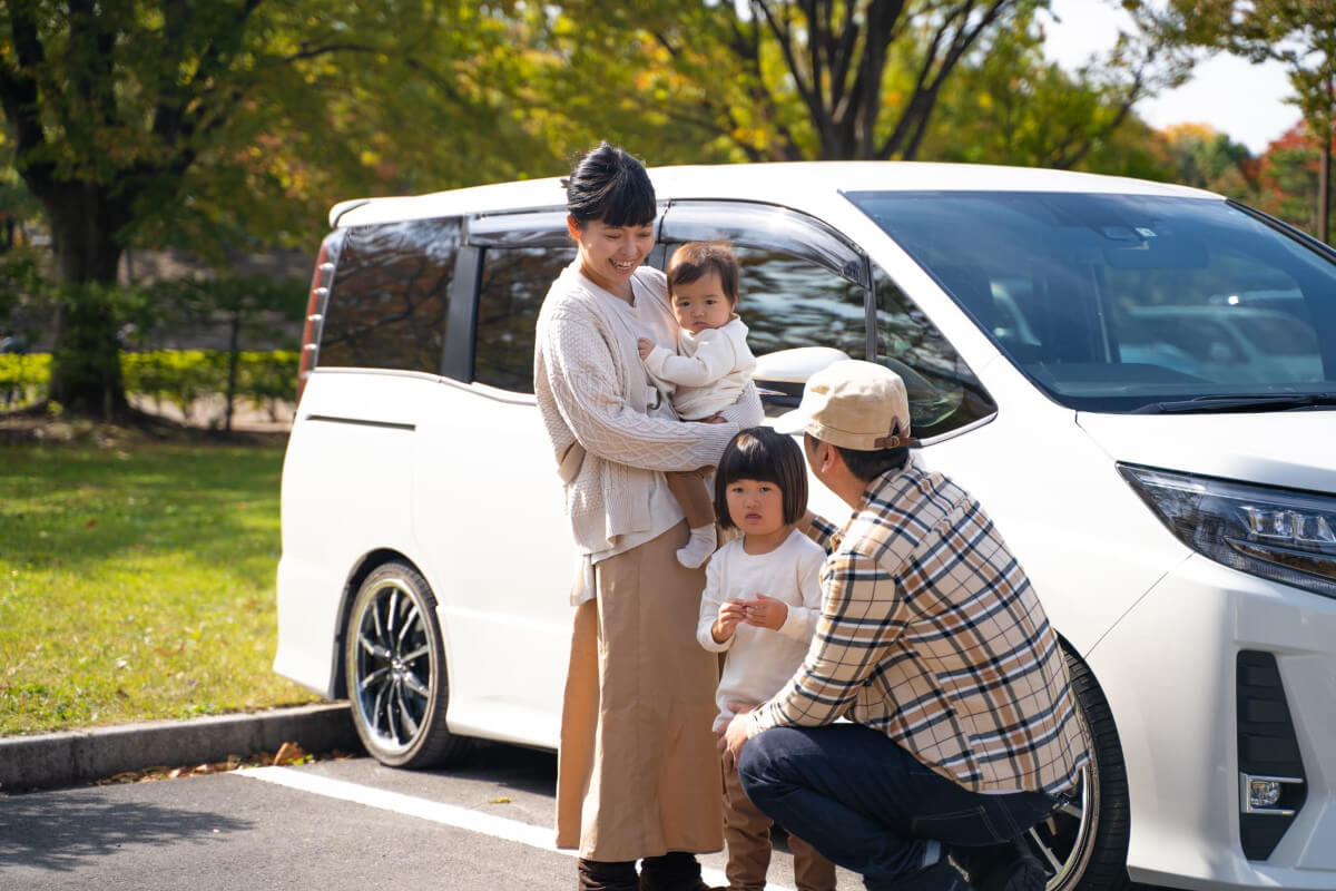 車の前に立っている家族